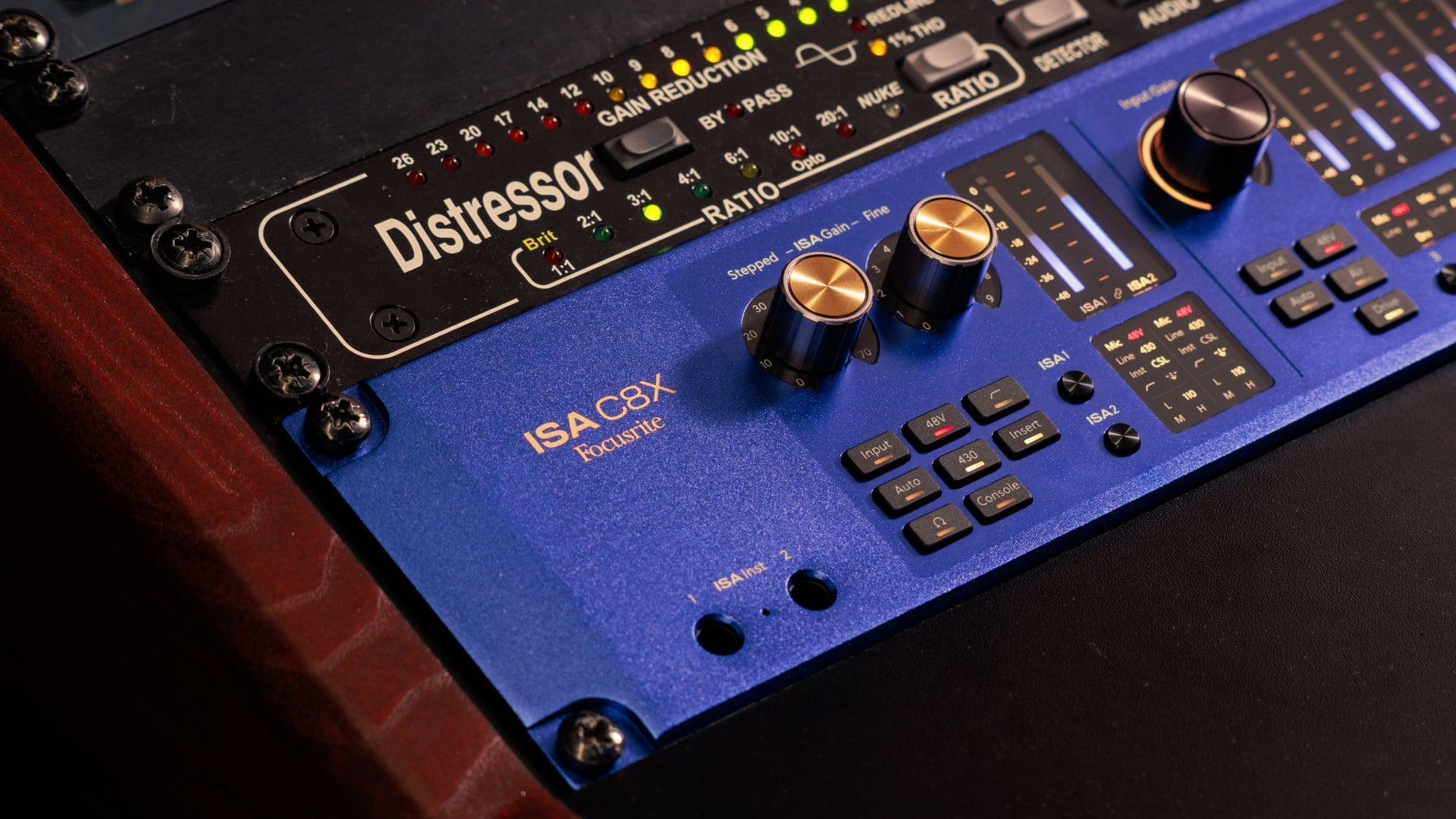 Blue audio interface with distressor module and dual gold-topped rotary knobs, slightly different angle and lighting