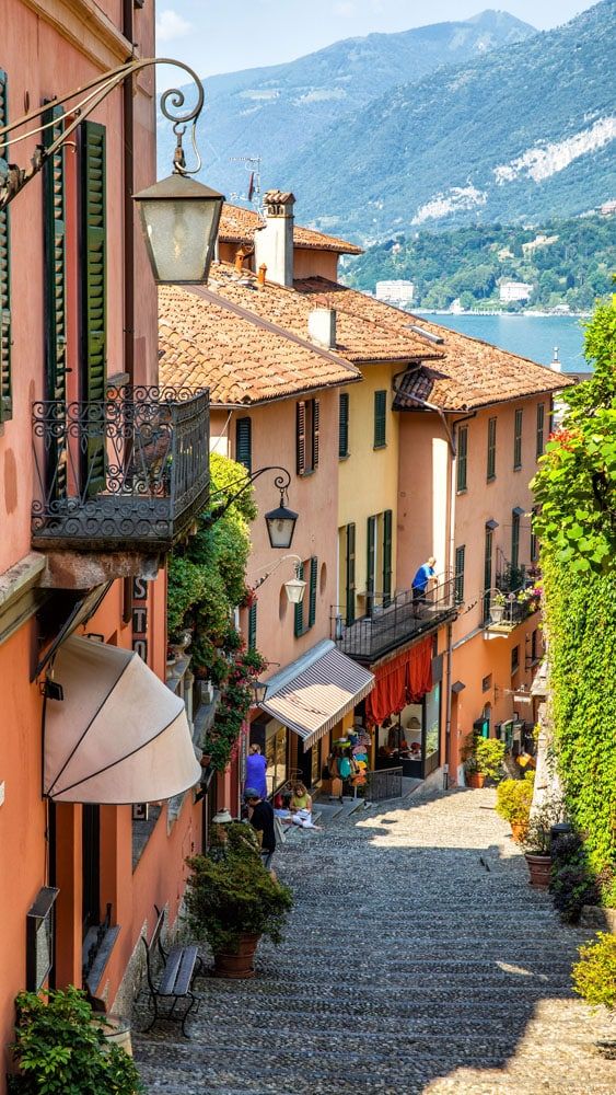 Colorful hillside buildings with terracotta roofs and ivy overlooking a mountain lake