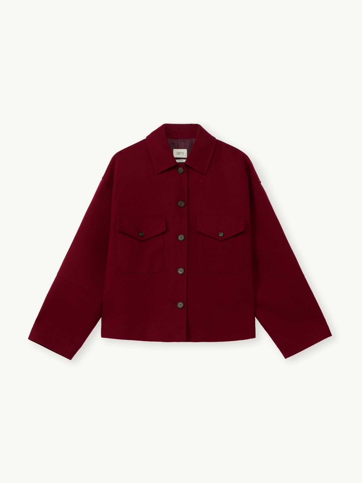 Close-up of burgundy jacket with collar, chest pockets, and olive-toned buttons